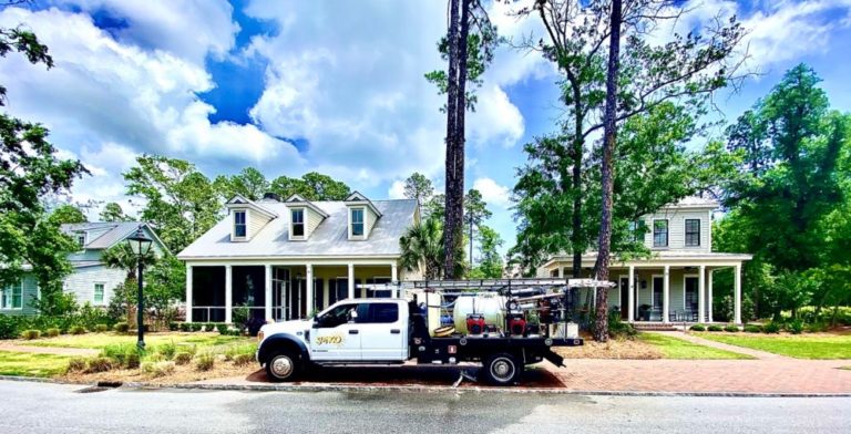 Sunco pressure washing vehicle in front of a home after a house washing service.